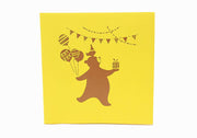 Front cover of card with yellow color features bear with a bird on the head and holding a gift and balloons